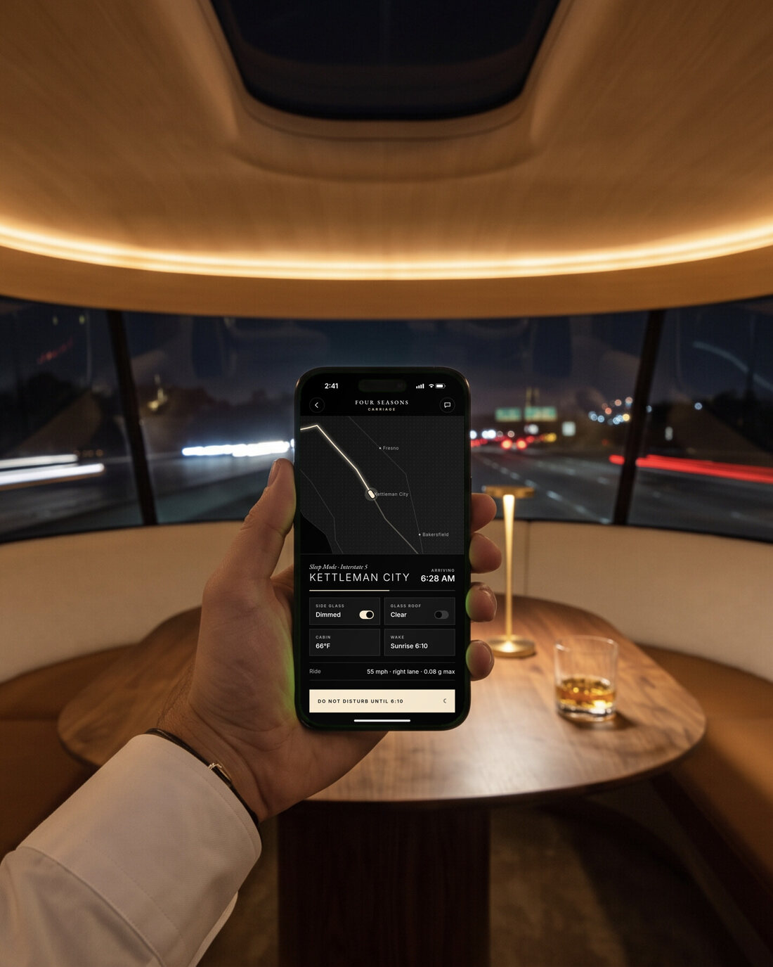 A hand holding an iPhone showing the app: ride