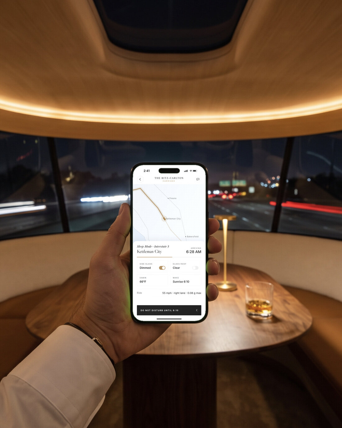 A hand holding an iPhone showing the app: ride
